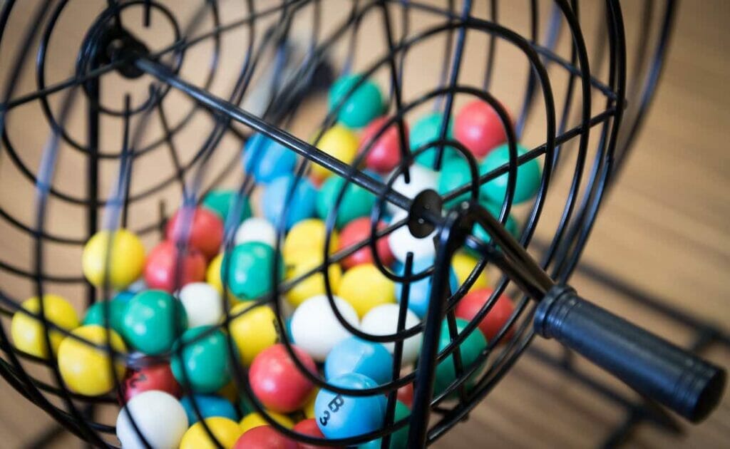 An old-school bingo cage with numbered balls inside of it.