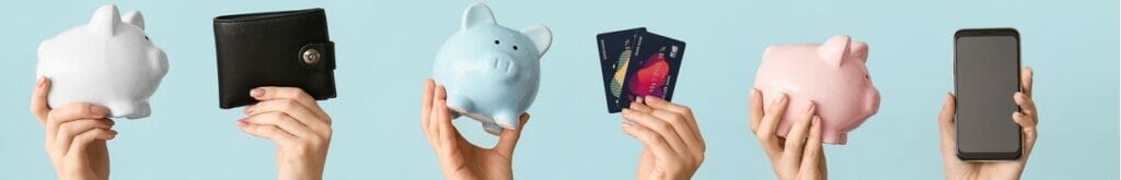 Hands holding up piggy banks, a wallet, bank cards and a cellphone.