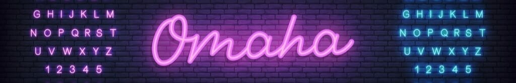The word ‘Omaha’ lit up in purple neon lights on a brick wall.