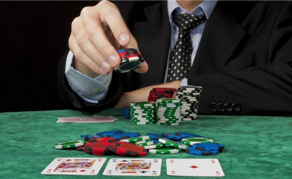 A player puts chips into the pot in front of three community cards.