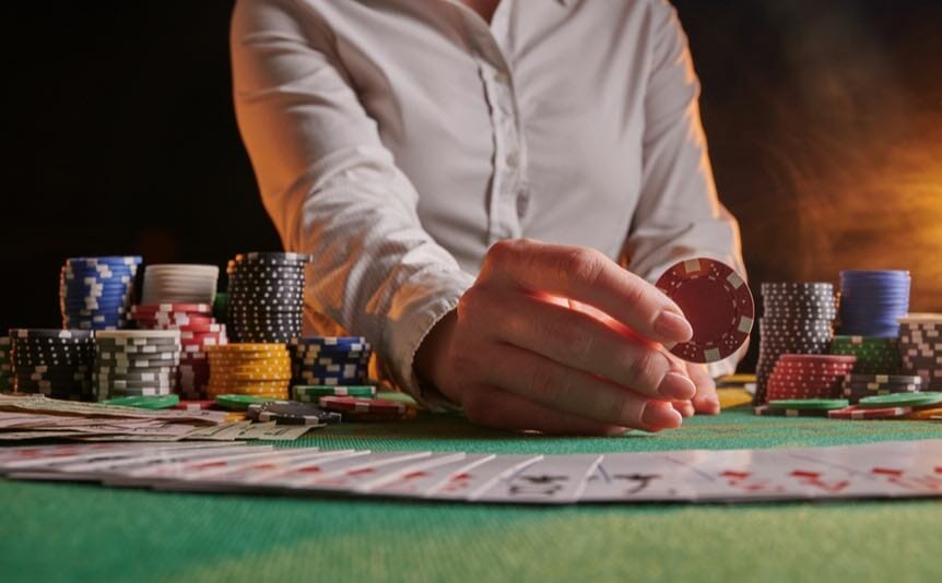 A croupier holds up a poker chip.