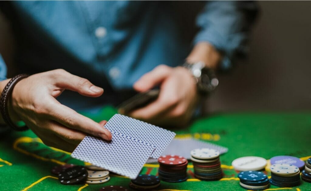 A poker player passes two cards face down on the poker table.