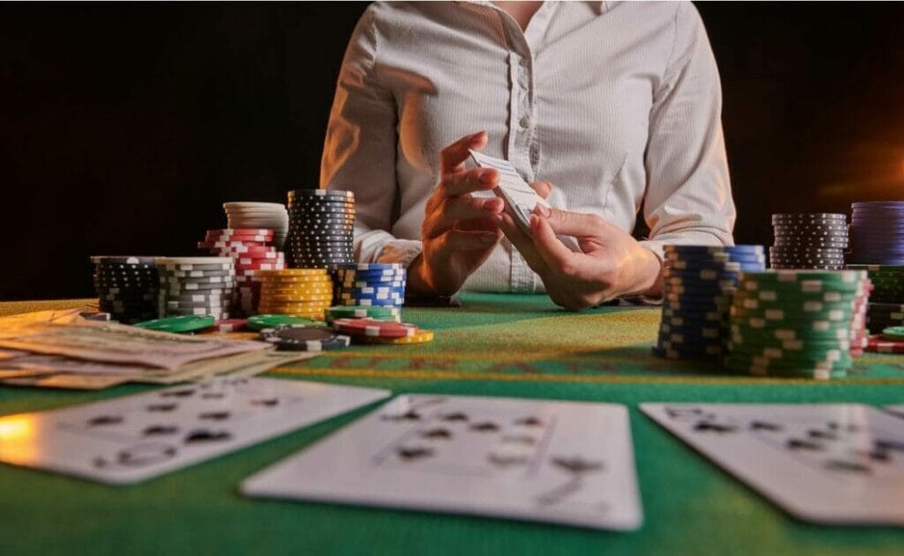 A croupier shuffles cards at a poker table.