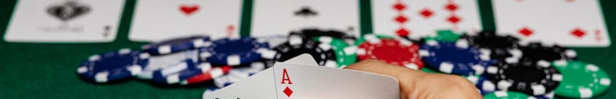 A poker player with the big blind button checks his hole cards.
