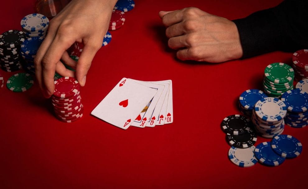A man takes a chip and has a royal flush on the table.