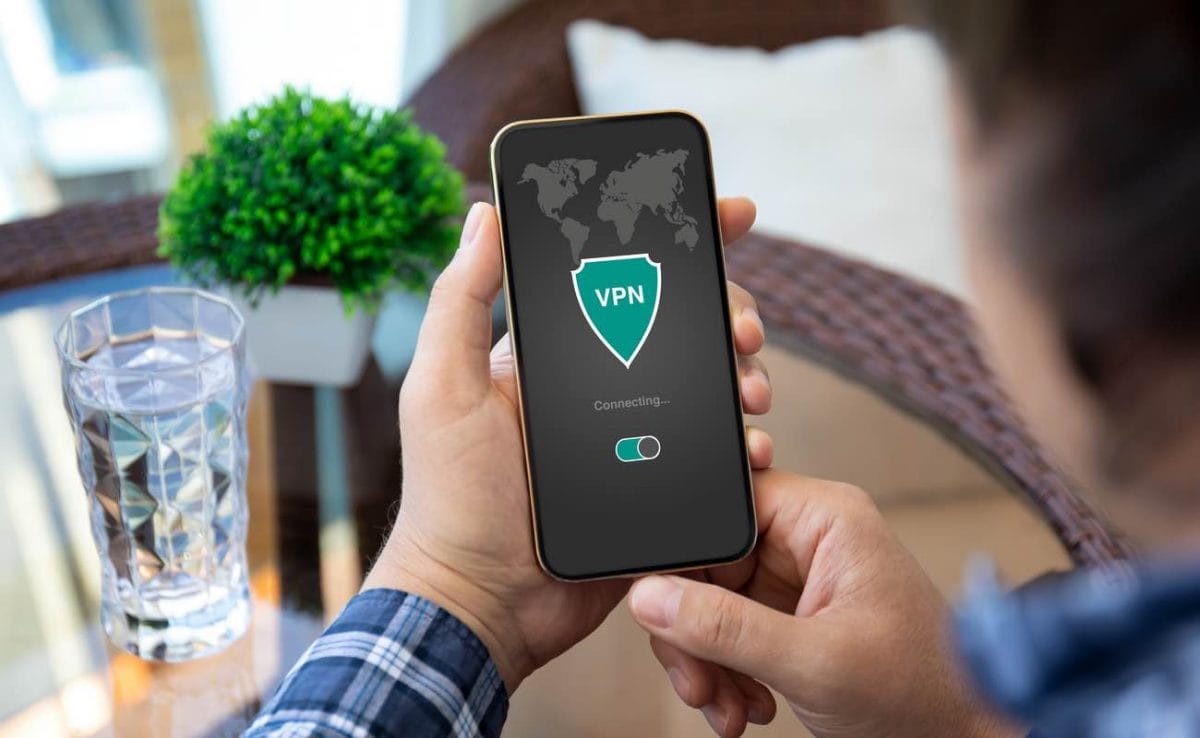 A man holds a phone with a VPN sign on it.