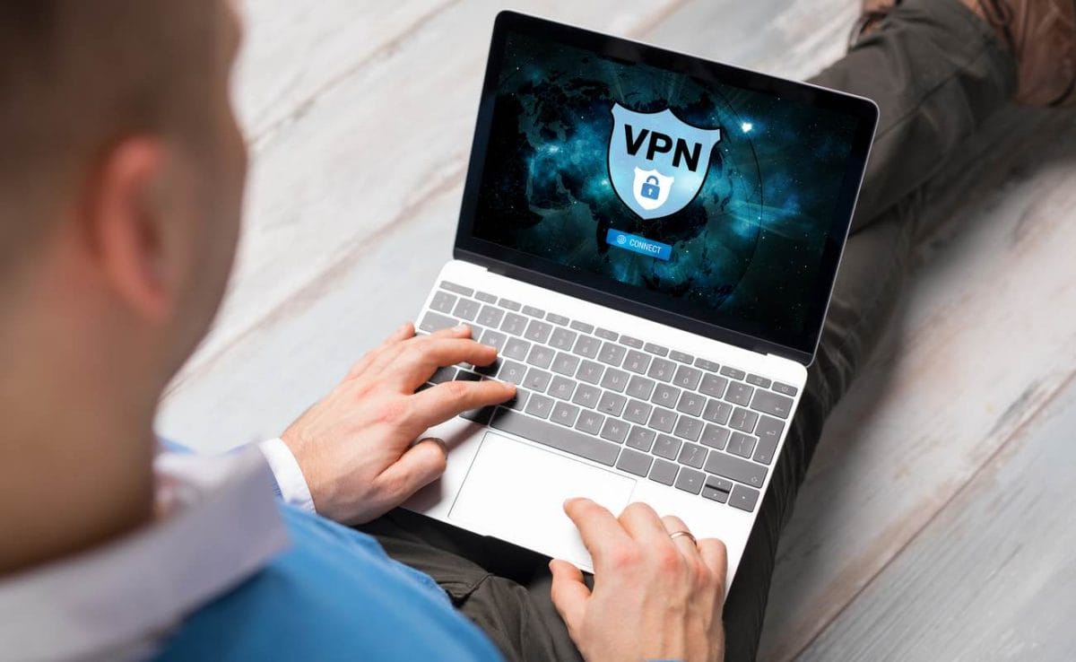 A man on his laptop with a VPN sign on the screen.