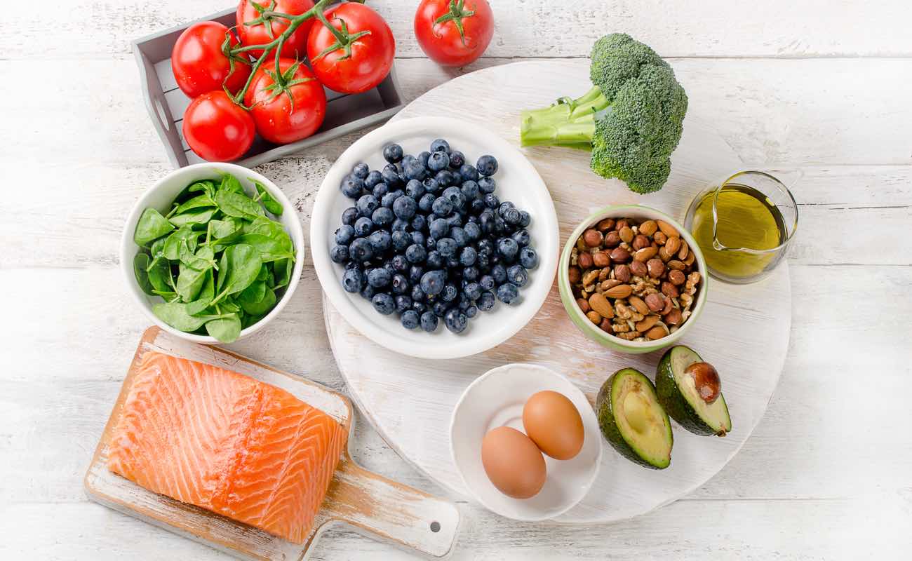 A platter of healthy foods like salmon, blueberries, broccoli, etc.
