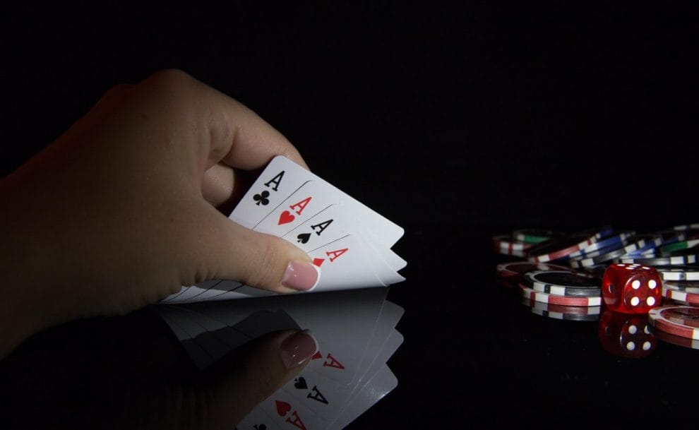 Poker player hand holding 4 A