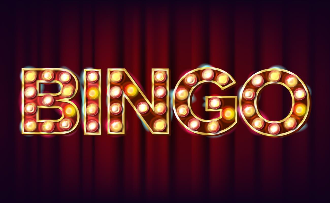 A bingo banner in lights on a red curtain background.
