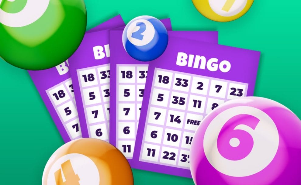 Purple bingo cards with a variety of different ball colors on a green background