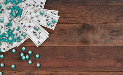 Bingo cards and numbers on a wooden table.