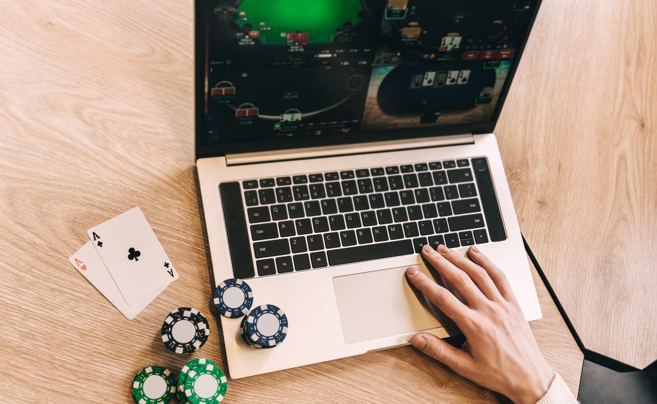 A person plays poker online on their laptop.