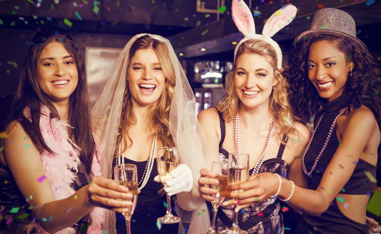 Four women dressed up for a bachelorette party.