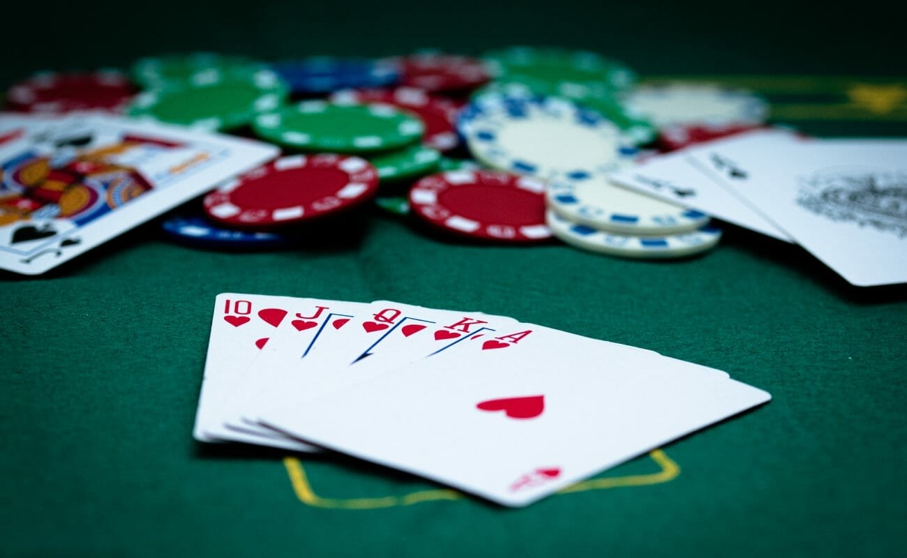 Poker cards and casino chips on a green felt table.