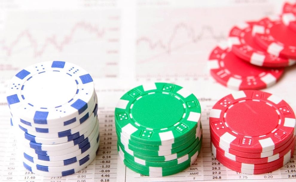 Stacks of poker chips on a page with graphs and stats.