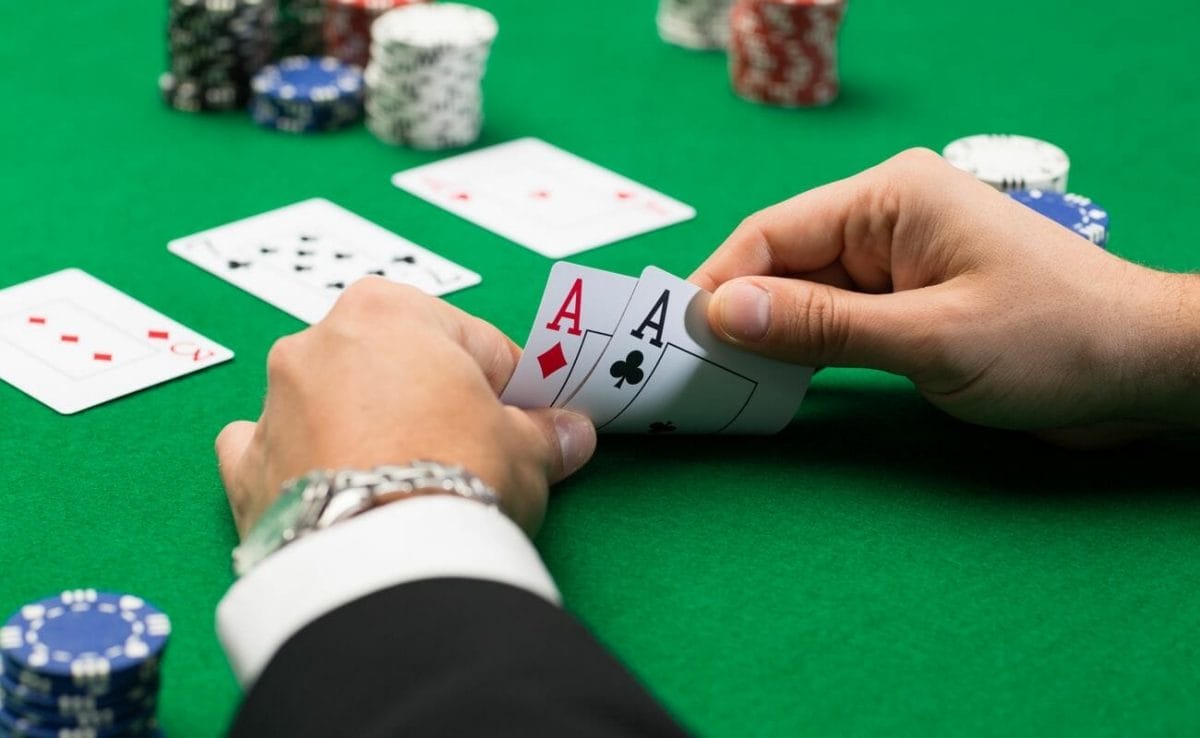 A poker player checks their hole cards in a game of Texas Hold’em.