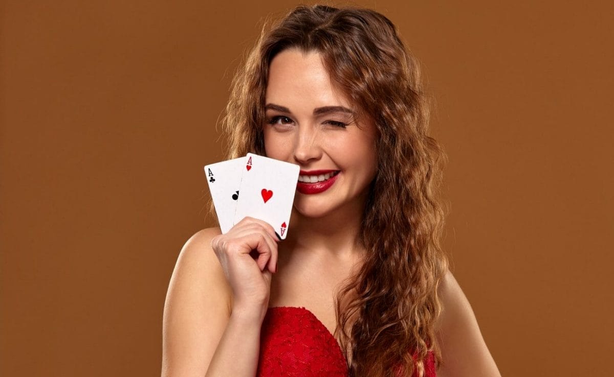 A beautiful woman winks and holds up a pair of aces.