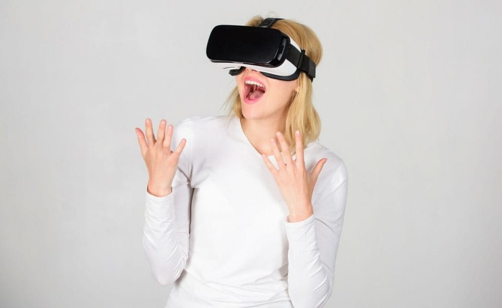 A woman is amazed while using a virtual reality headset.