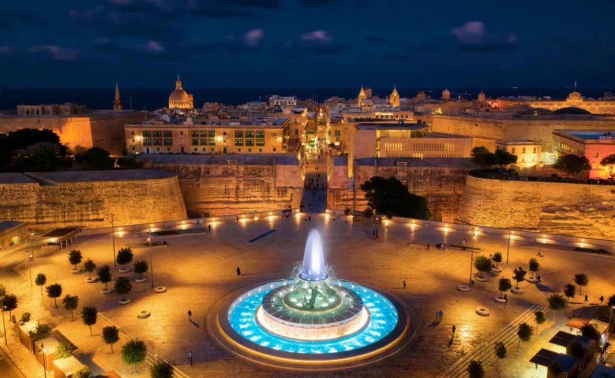 A fountain lit up at night in Valletta, Malta.