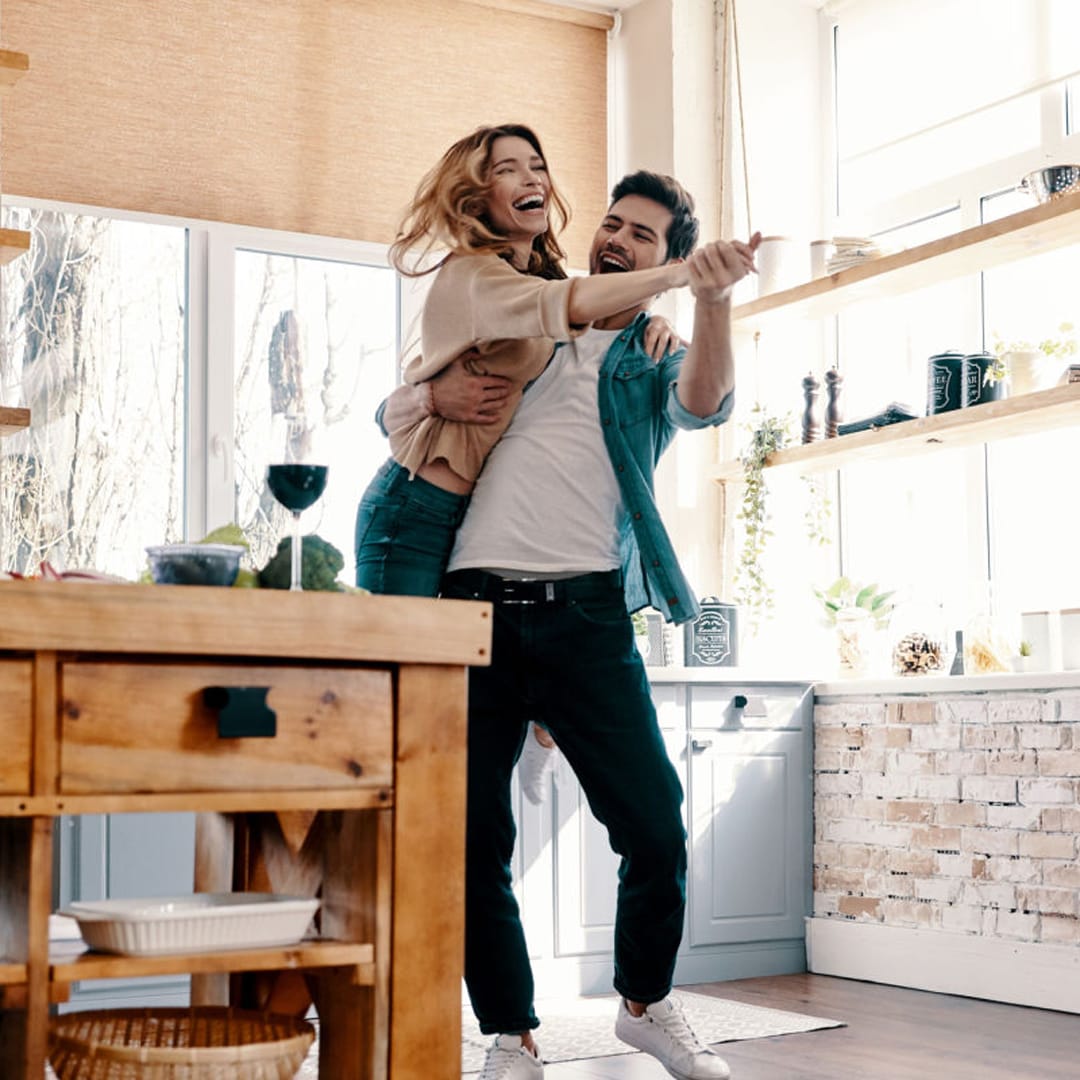 A couple dancing in the kitchen.