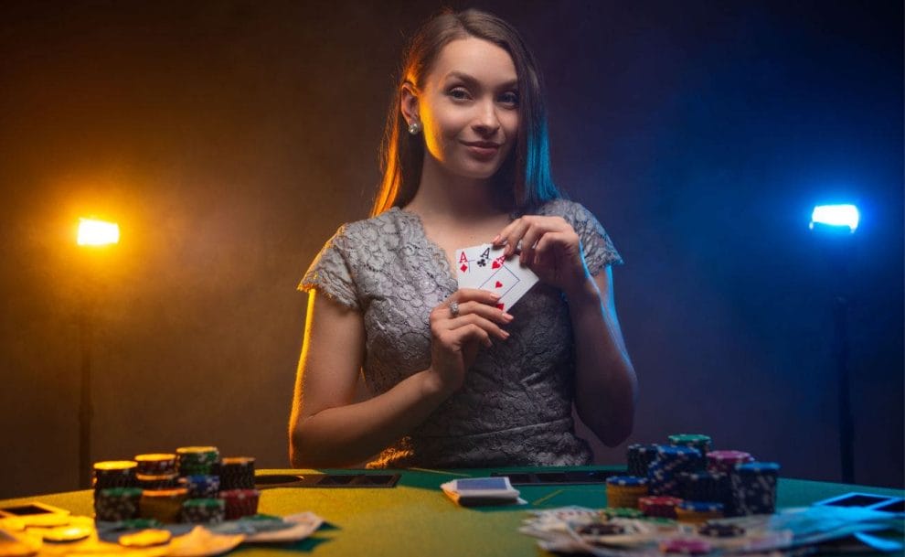 A woman at a casino table holding three aces.