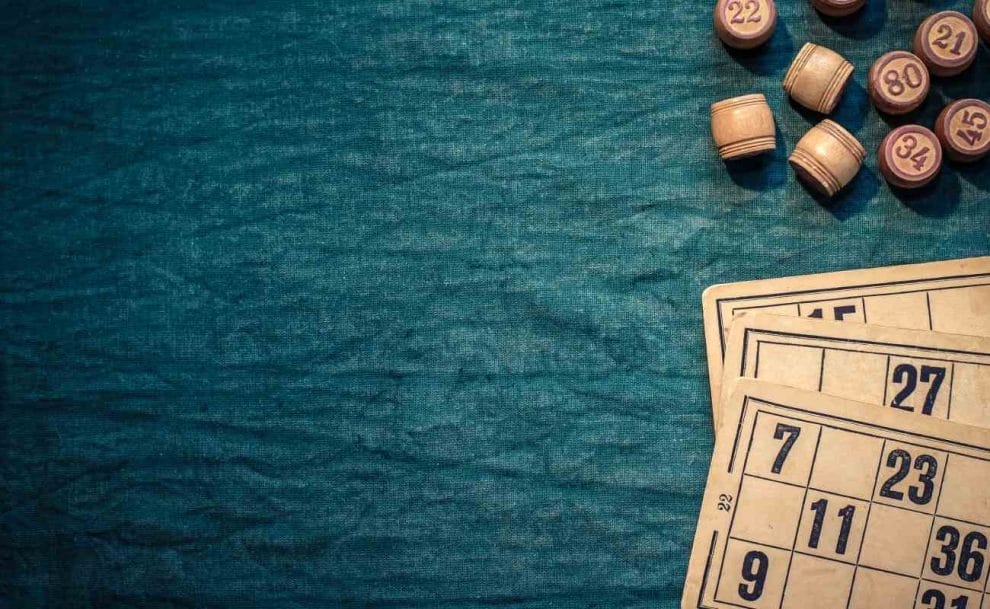 Wooden bingo cards and barrels on a table.