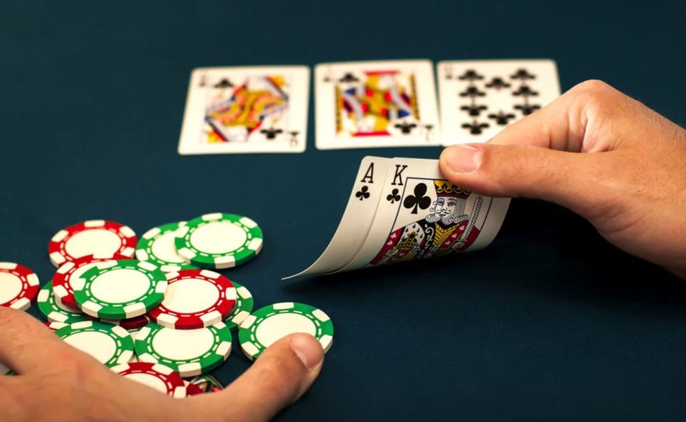 A player looks at their hand at the poker table.