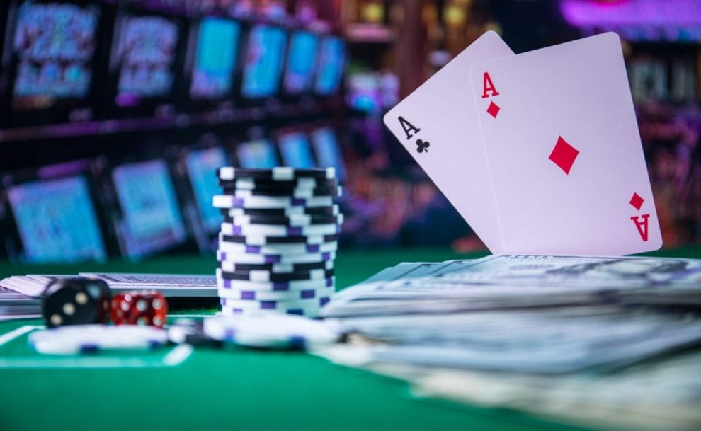 Two ace cards and casino chips on a green felt table.