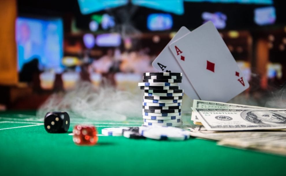 Casino chips, playing cards and dice on a green felt table.