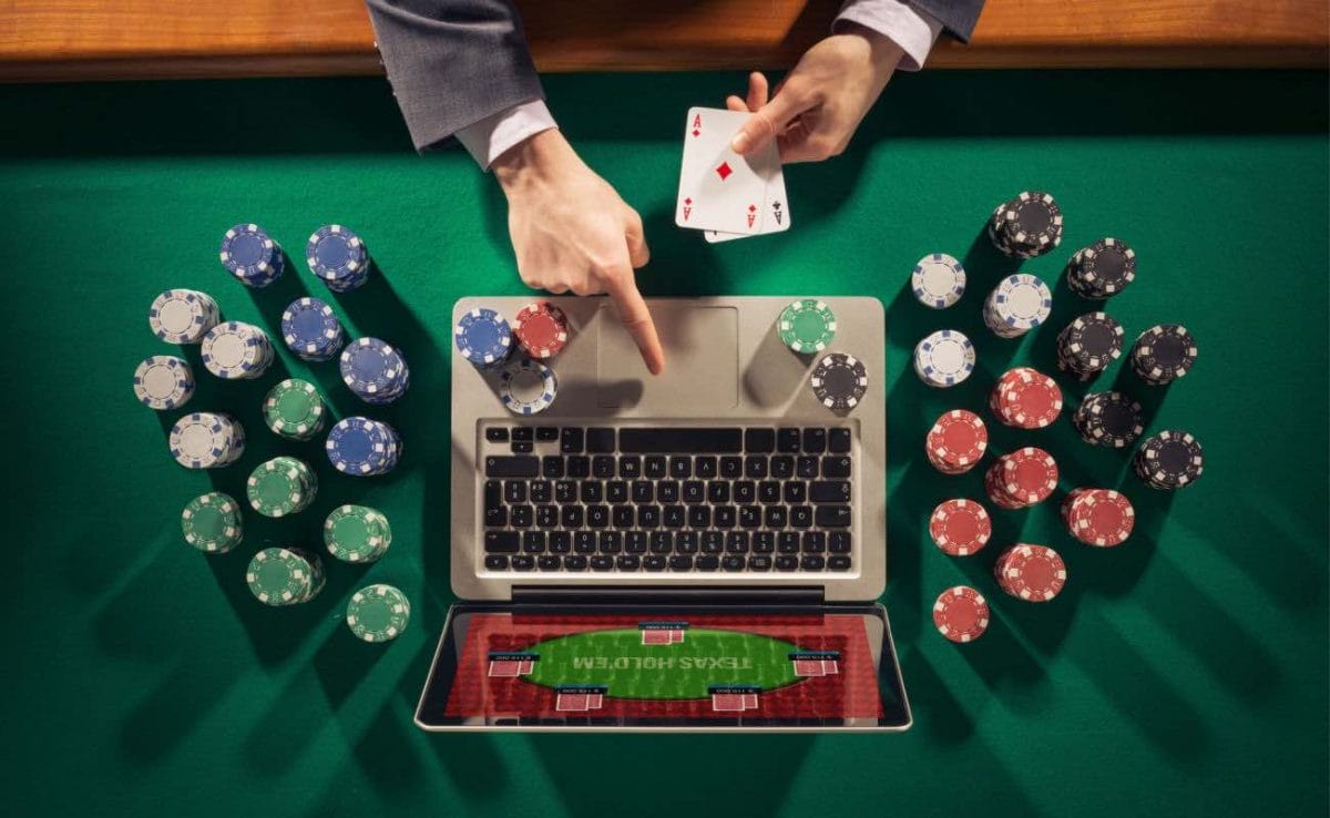 Top view of a laptop surrounded by casino chips.