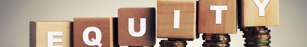 “Equity” written on wooden blocks stacked on bronze coins.