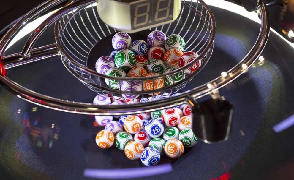 Colorful bingo balls in a round glass bowl.