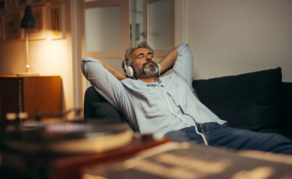 A person wearing headphones and relaxing on a couch.