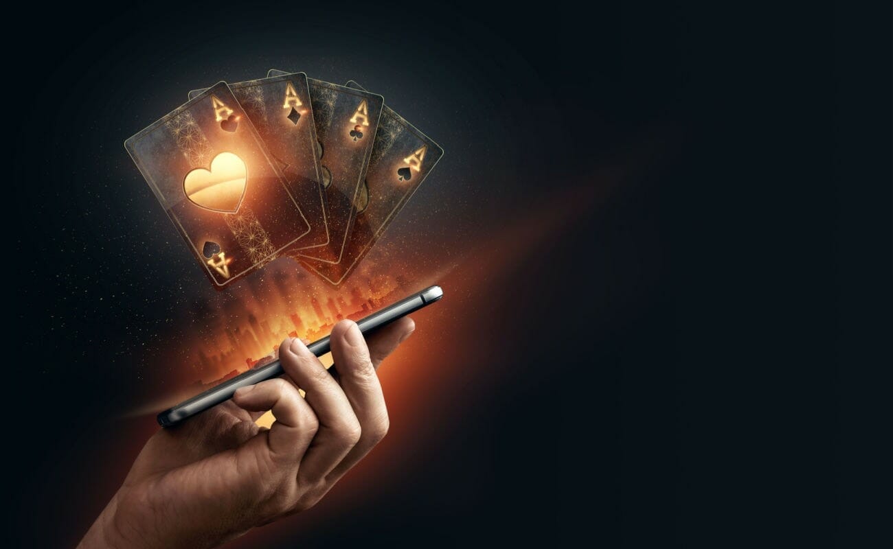 A 3D rendering of virtual playing cards coming out of a smartphone.