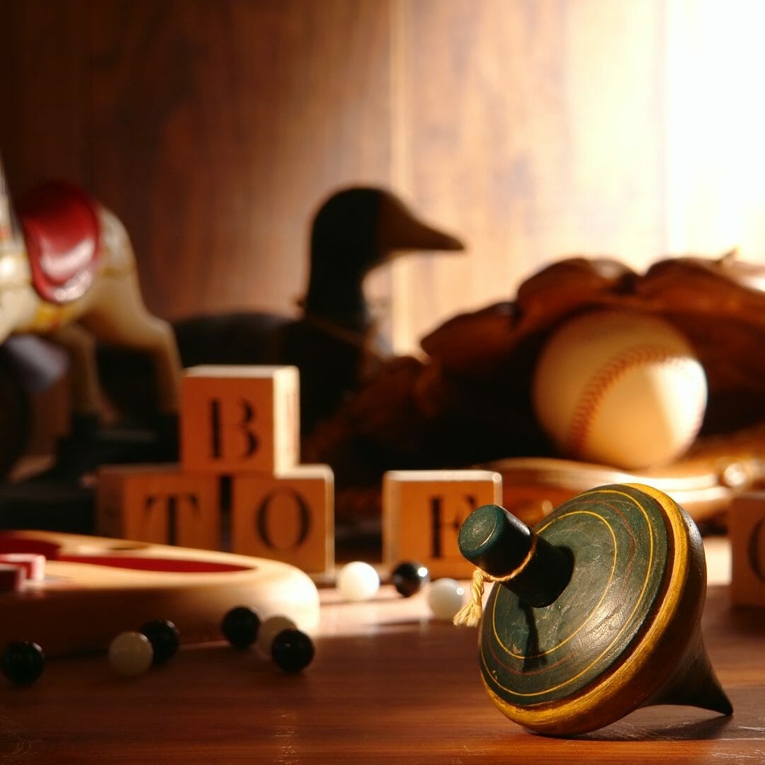 A collection of classic games and toys, including a wooden spinning top.