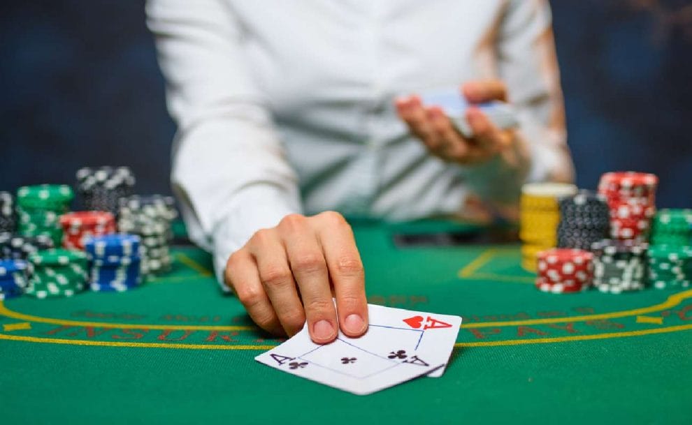 A croupier giving out two aces at a poker table.