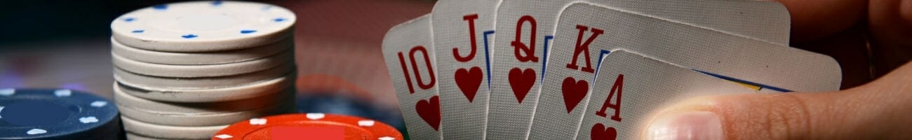 A royal flush featured on playing cards next to stacks of casino chips.