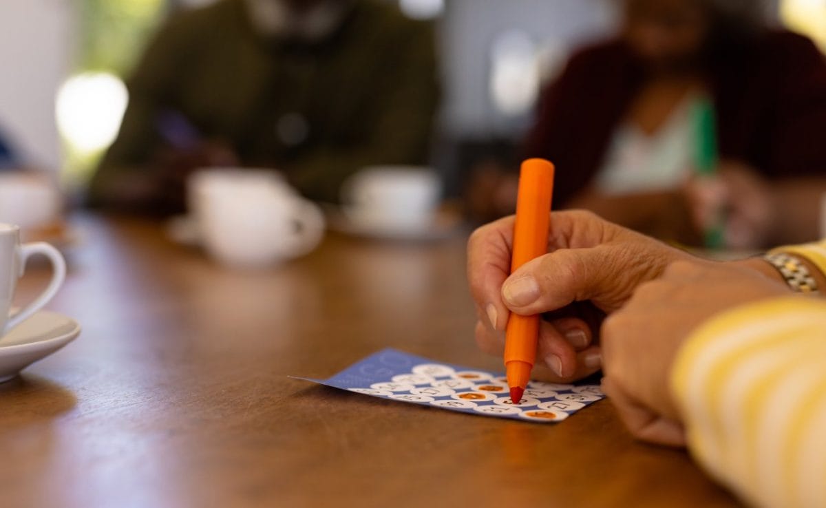 A woman marking numbers on a bingo card.