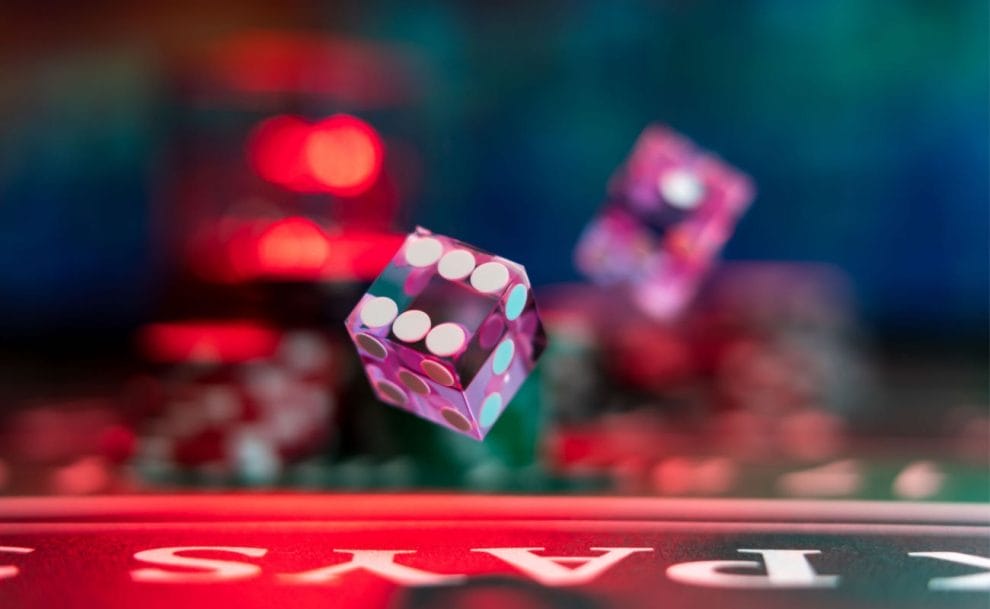 A red dice in the air against a blurred background.
