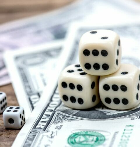 Stacks of casino dice on dollar bills.