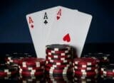 Three aces positioned vertically on a black background.
