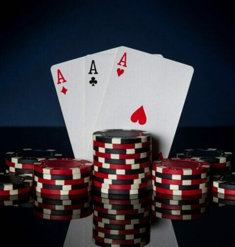 Three aces positioned vertically on a black background.