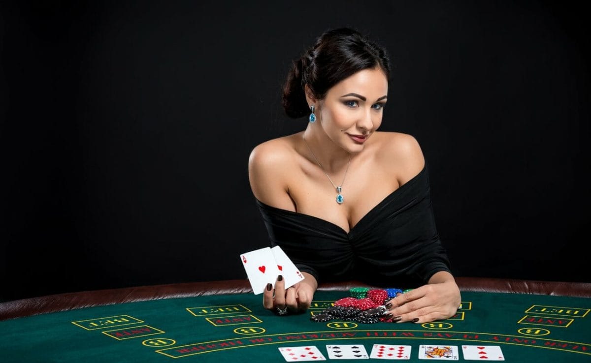 A woman playing poker at a casino reveals her hand of two aces. 
