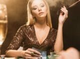A woman looks at her hole cards.