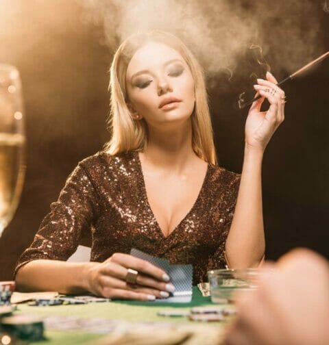 A woman looks at her hole cards.