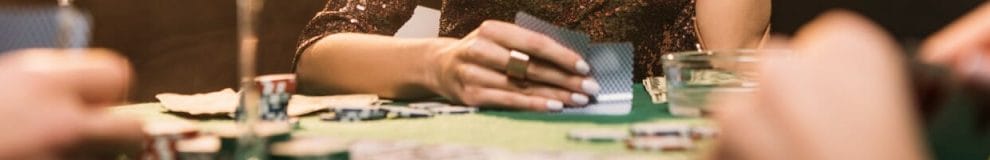 A woman looks at her hole cards.