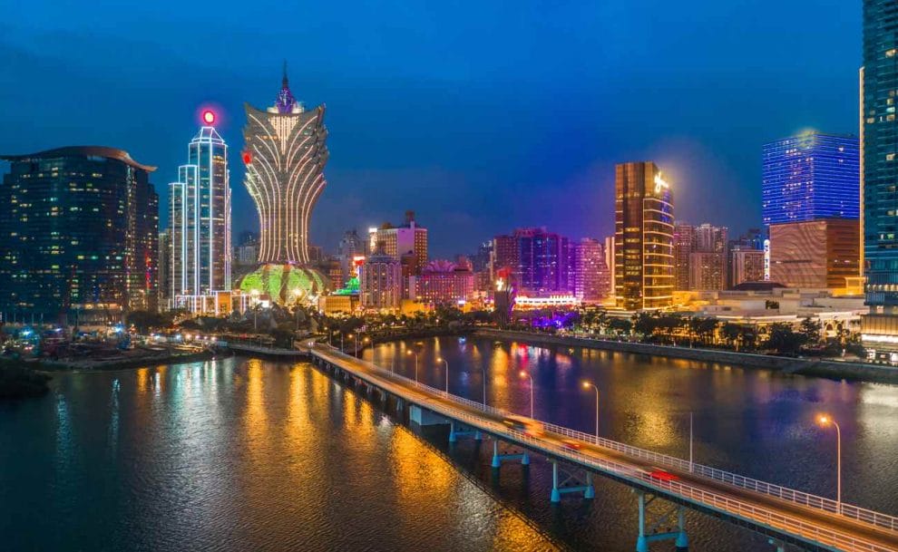 The Macau city skyline at night featuring the Grand Lisboa hotel and casino.