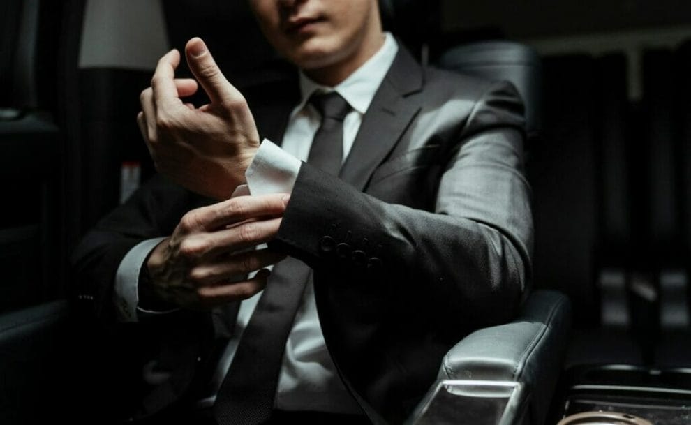 A man straightens his shirt cuffs.