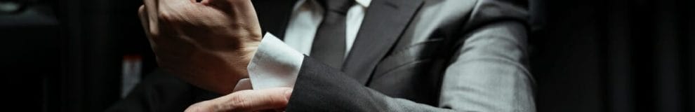 A man straightens his shirt cuffs.